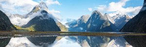 Berge spiegeln sich im glatten Wasser am Milford Sound in Neuseeland.