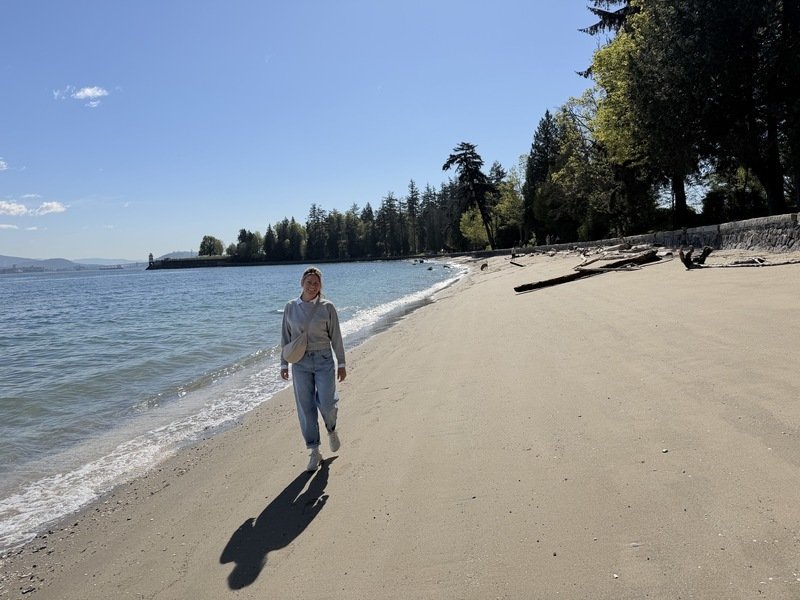 Eine Frau, die an der Westküste von Vancouver Island am Strand entlangläuft