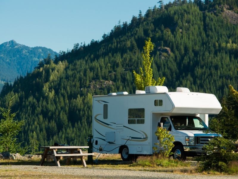 Wohnmobil aus einem Campingplatz und bewaldeten Bergen