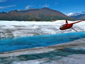 Helikopter fliegt ĂĽbers Gletschereis in Alaska
