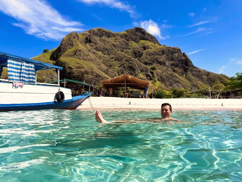 Mann schwimmt am Pink Beach in Indonesien