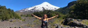 Frau vor schneebedecktem Vulkan in Chile