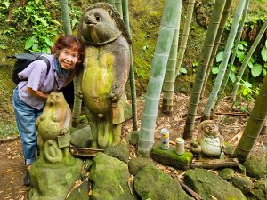 Guide an Steinstatuen zwischen Bambuspflanzen in Kamakura