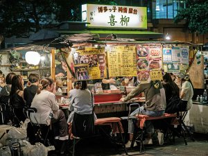 Yatai Imbissstand mit vielen Menschen am Abend in Fukuoka