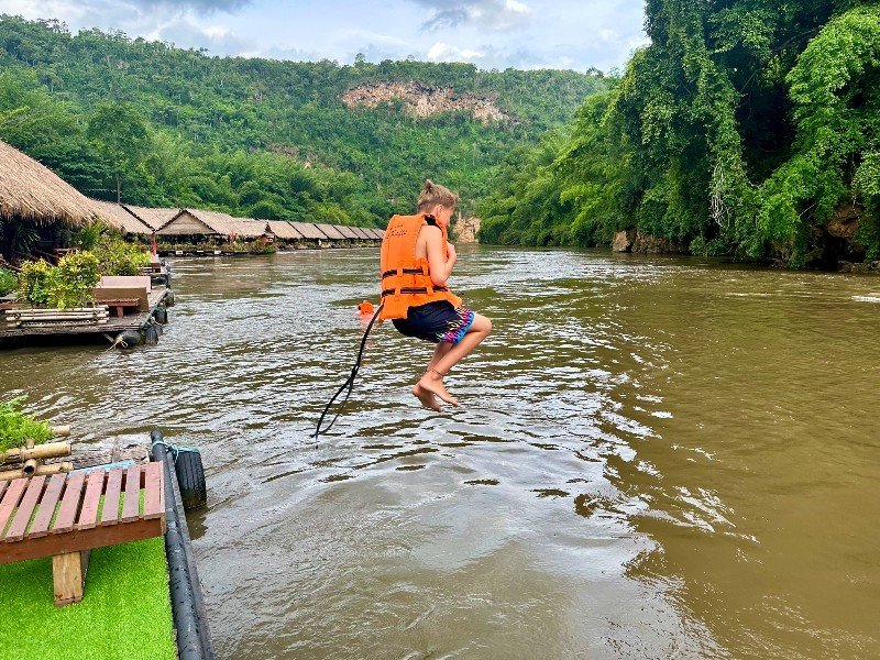 Kind springt zum Baden in den River Wai in Thailand