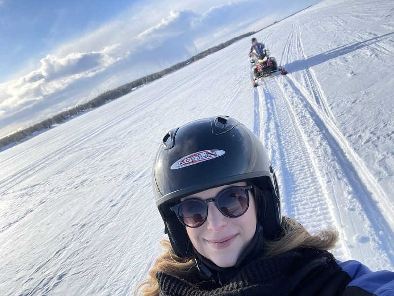 Reisende fährt mit dem Schneemobil in Lappland