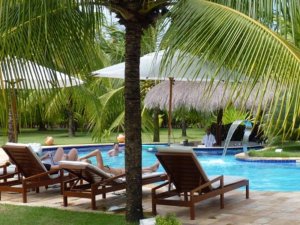 Hotelgäste im von Palmen gesäumten Pool