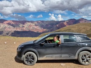 Touristin in einem Auto vor einer Berglandschaft in Argentinien