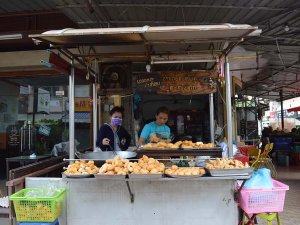 Verkäufer an einer typischen Garküche in Laos