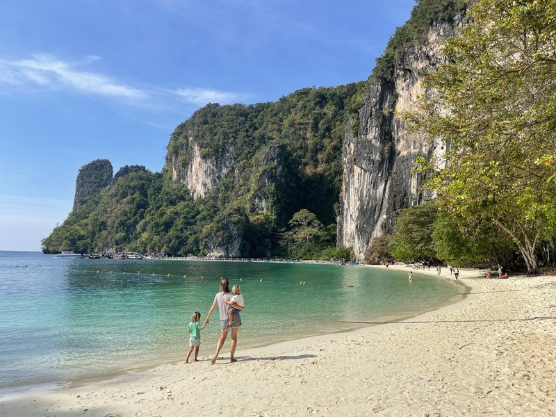 Familie spaziert am Strand mit Karstfelsen in Ao Nang, Thailand