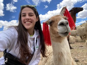 Reisespezialistin Maite mit einem Alpaka in Peru