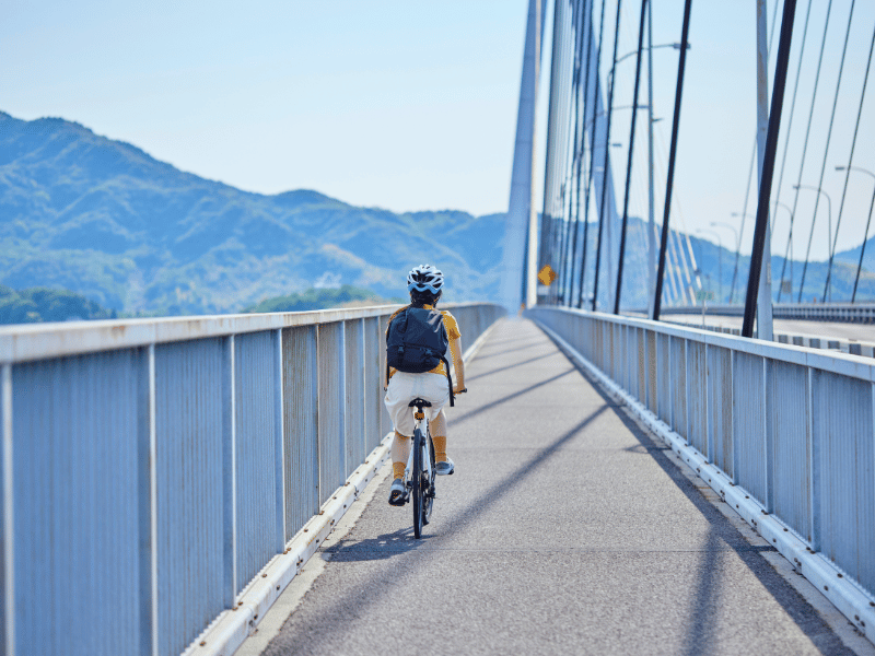 Reisende fährt mit dem Fahrrad über die Shimanami Kaido Brücke in Japan