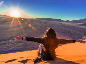 Frau zum Sonnenaufgang im Sossusvlei Namibia