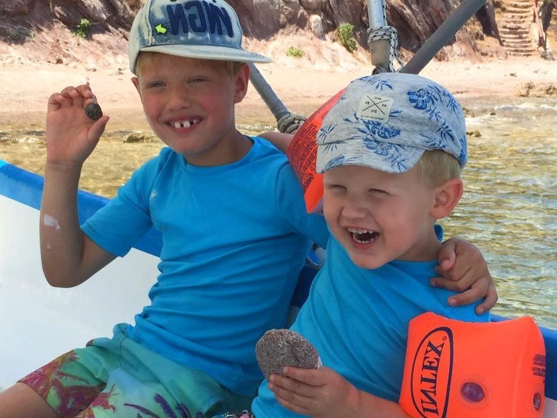 zwei lachende Kinder auf einem Boot