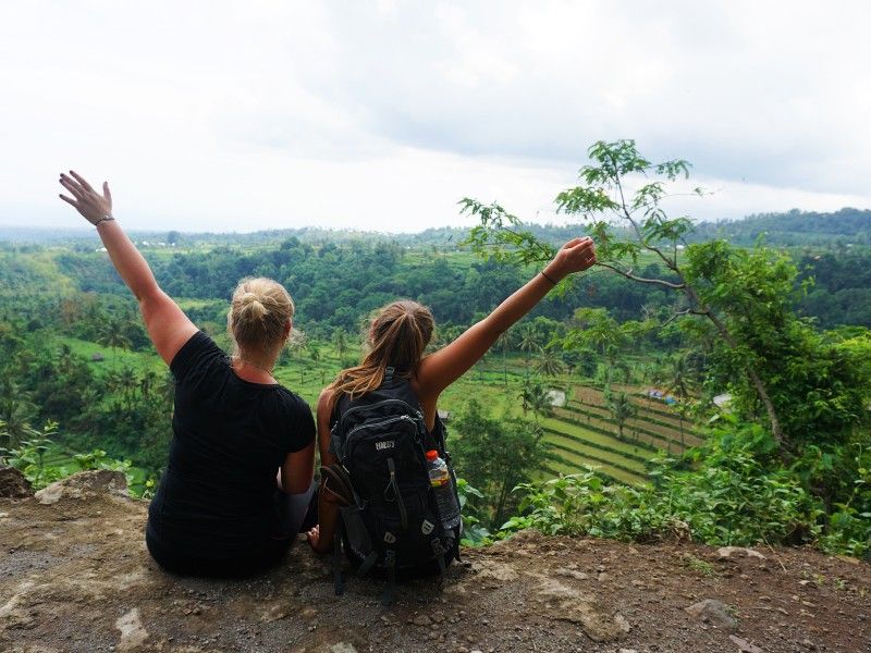Touristinnen posieren vor der Landschaft in Senaru, Indonesien