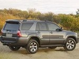 Schwarzer Toyota 4 Runner vor einem bewuchertem Hügel