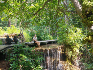 Tourist an einer Ebene der Erawan Wasserfälle in Kanchanaburi, Thailand