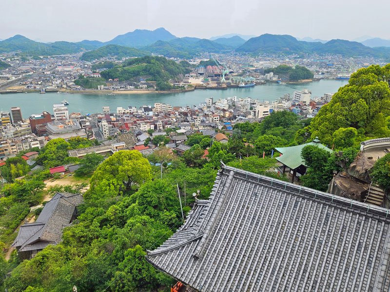 Ausblick über die Stadt und den Hafen von Onomichi von einem Hügel im Sommer