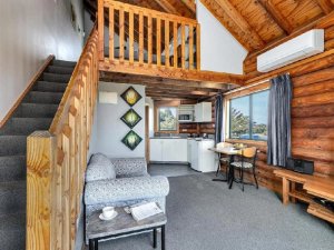 Innenansicht des Chalets inkl. Küche, Sitzgelegenheiten und Treppe zum Schlafbereich