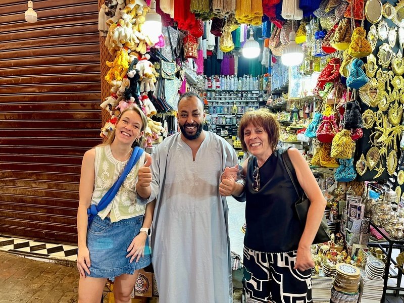 Reisende mit einem Local vor einem kleinen Geschäft in Marrakesch, Marokko