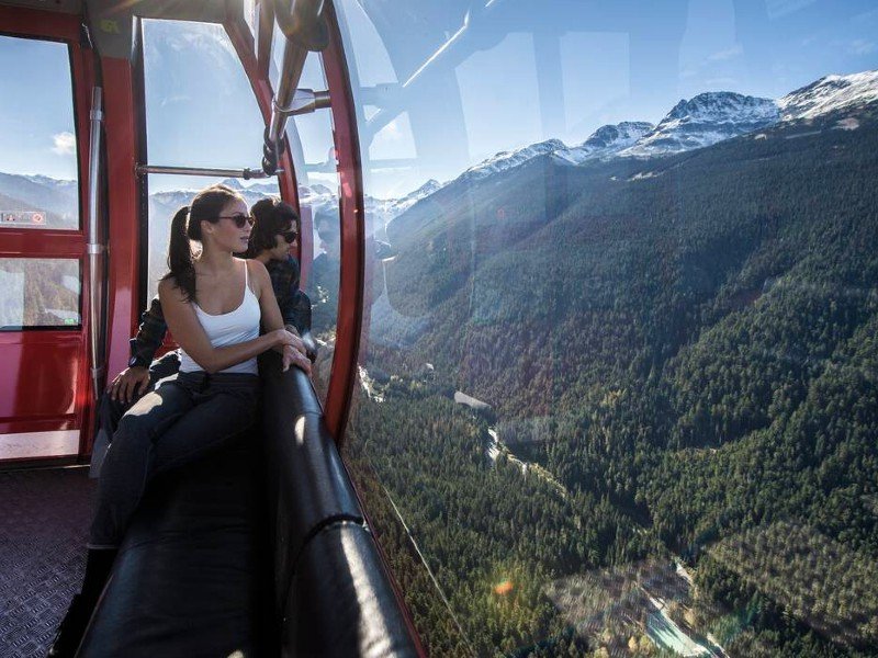 Eine Person in der Peak 2 Peak Gondola in Whistler, die nach draußen schaut.