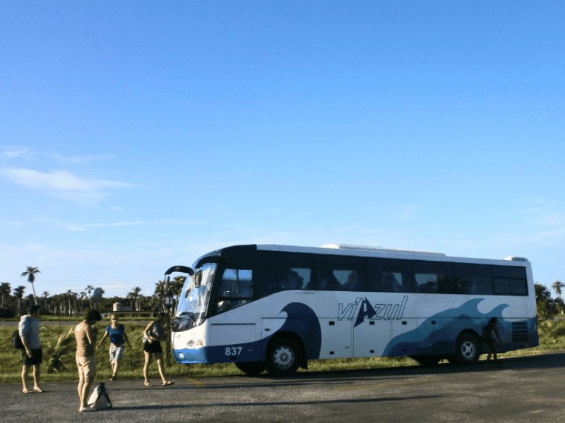 Weiß-blauer Viazul-Bus mit wartenden Menschen unter blauem Himmel in Trinidad, Kuba