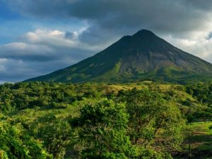 Landschaft in Costa Rica mit Dschungel im Vordergrund und einem Vulkan im Hintergrund
