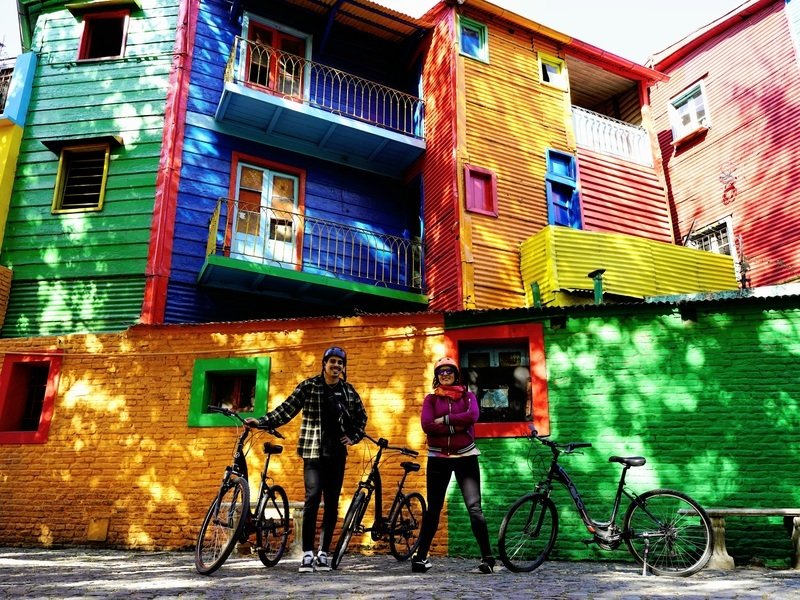 Reisende mit Fahrrädern vor einem bunten Haus in Buenos Aires, Argentinien