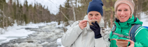 Frauen trinken Getränk im Schnee