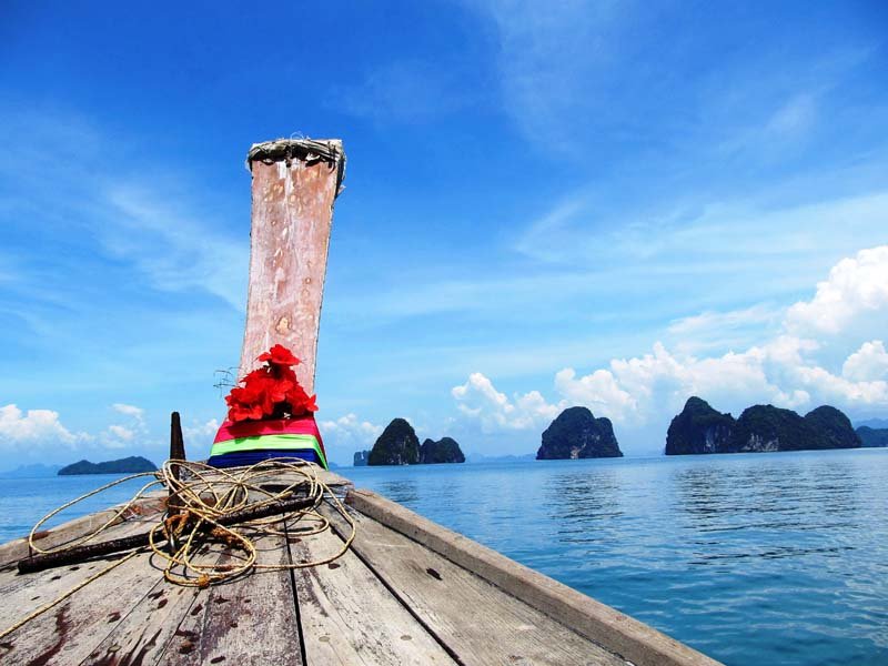 Longtailboot vor Felsen in der Phang Nga Bucht in Thailand