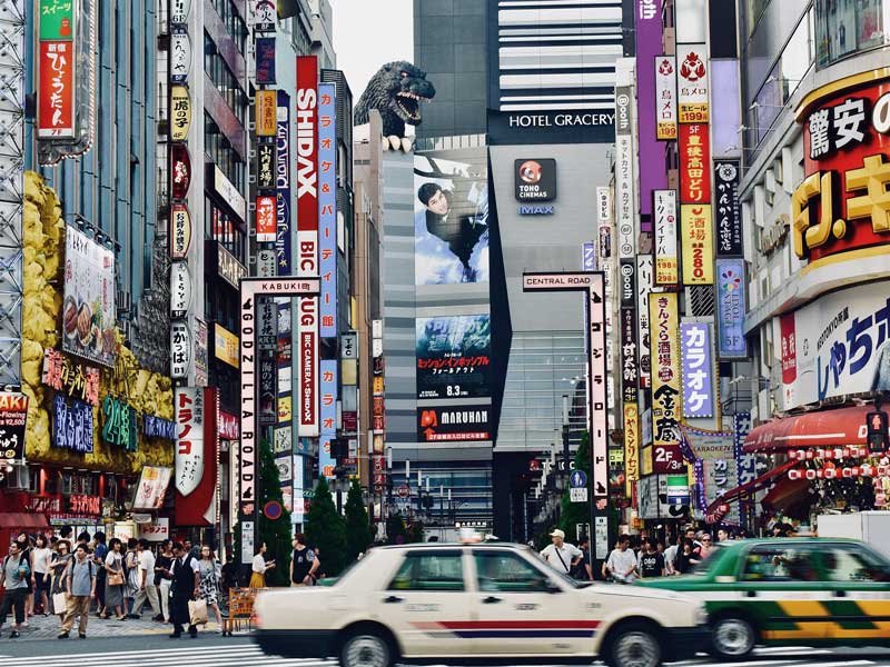 Godzilla über den Dächern in einer Straße in Shinjuku