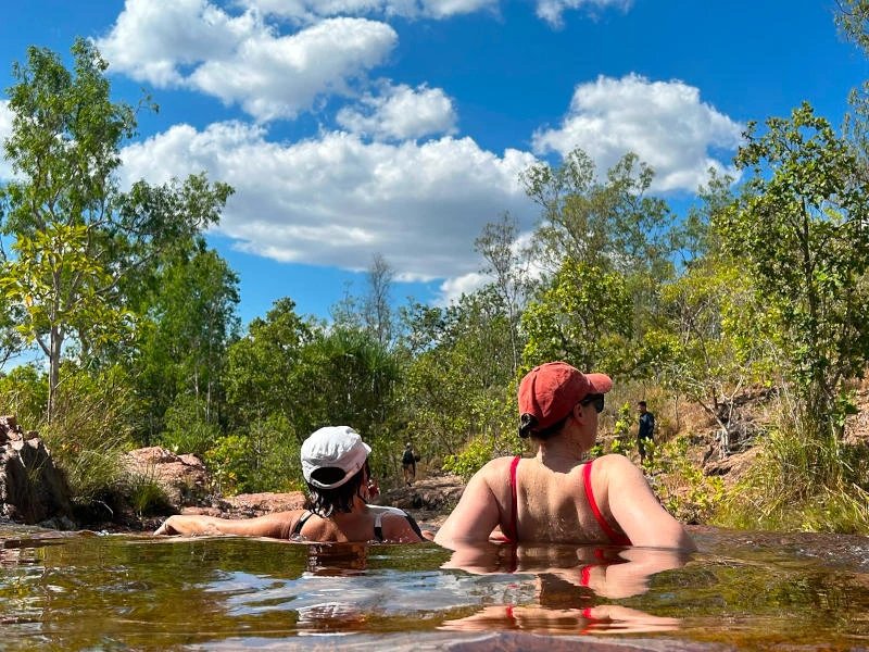 Menschen schwimmen bei einem Wasserfall im Litchfield Nationalpark, Australien