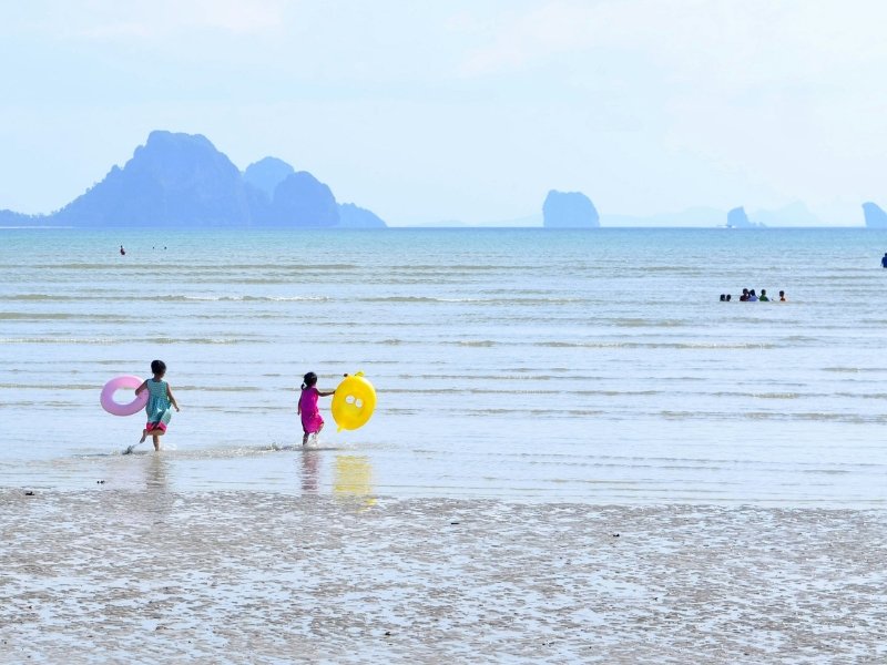 Kinder spielen am Strand