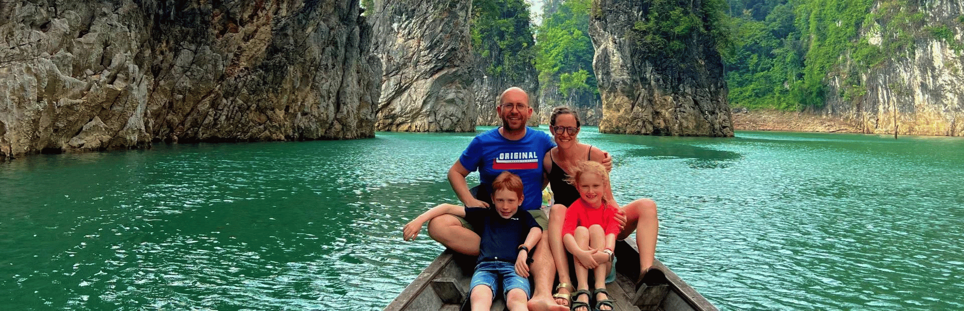 Familie auf einem Boot zwischen den Karstfelsen auf dem Racha Praba Stausee im Khao Sok Nationalpark in Thailand