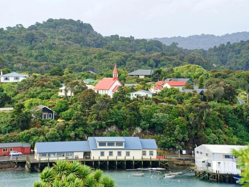 Vereinzelte Gebäude am Wasser in der Halfmoon Bay in Oban auf Stewart Island, Neuseeland