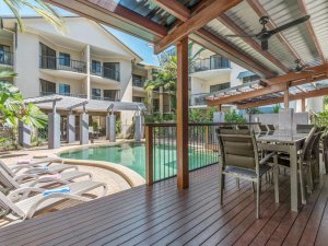 Liegen und Holzterrasse an einem Pool im Hotel in Port Douglas, Autsralien