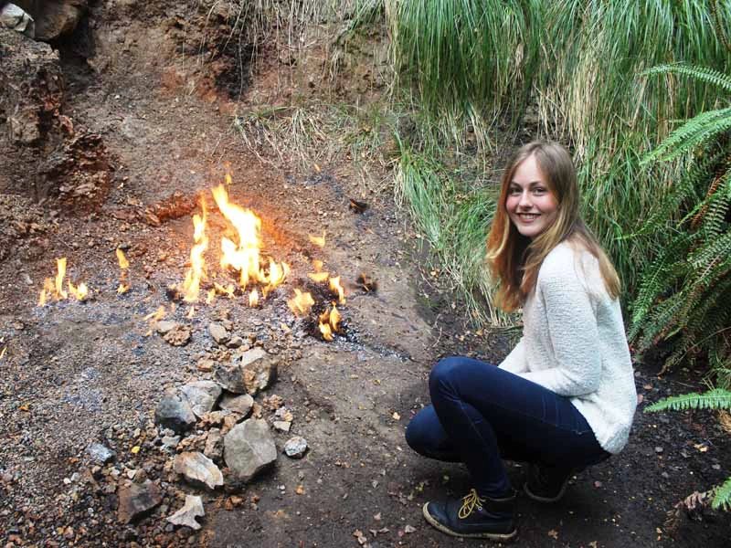 Frau sitzt bei den Natural Flames in Murchison