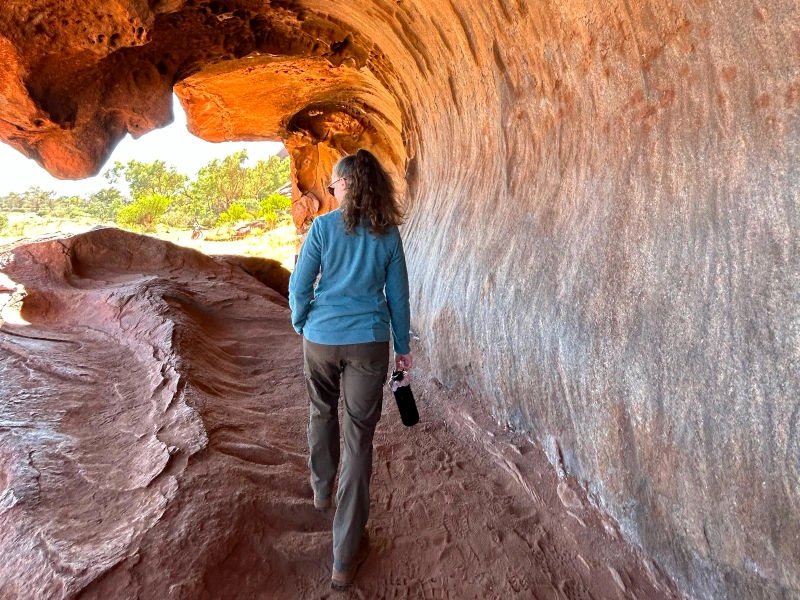 Frau wandert durch Felsformation des Uluru in Australien