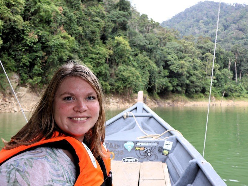 Reisende fährt auf einem Boot über einen Fluss im Belum Regenwald in Malaysia