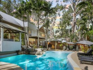 Pool mit Liegen und Palmen im Hintergrund
