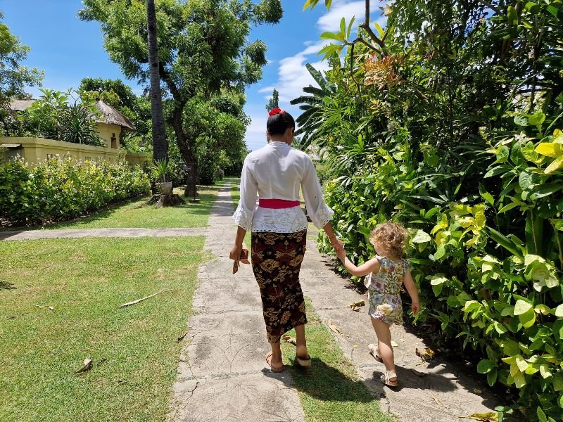 Kind mit Mutter im Hotelgarten von Pemuteran auf Bali