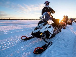 Schneemobiltour bei Sonnenuntergang in Lappland