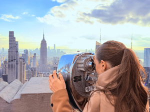 Frau am Fernglas in New York in den USA