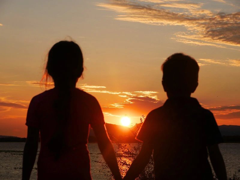 Kinder blicken in den Sonnenuntergang in Afrika