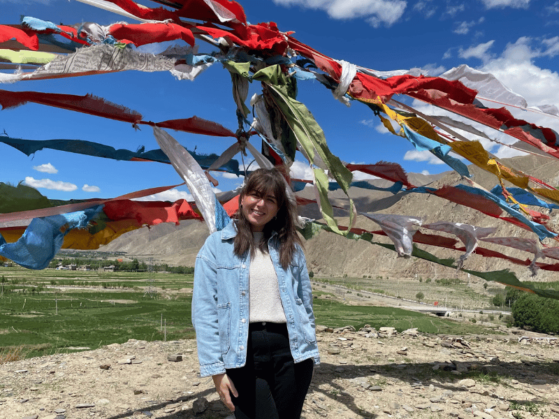 Touristin vor Gebetsflaggen in Tibet