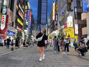 Reisende auf den belebten Straßen zwischen Geschäften in Tokio bei Nacht