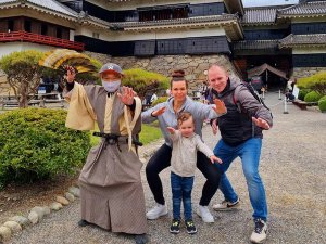 Familie macht Samurai Gesten vor Burg in Japan