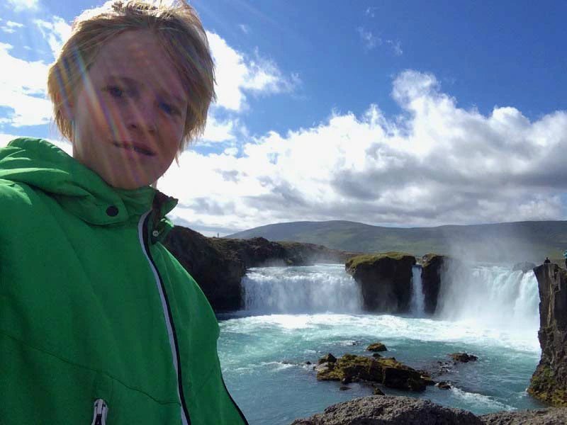 Junge am Wasserfall in Island