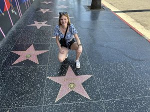 Frau kniet auf dem Walk of Fame